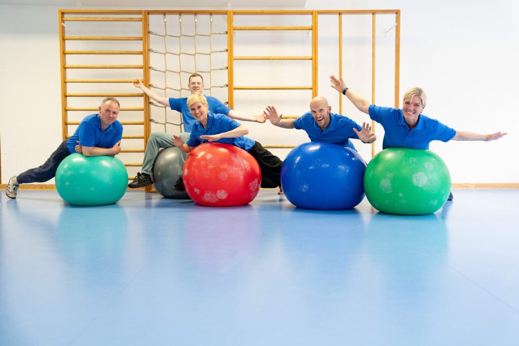 Mitarbeiter der Ostseeklinik Zingst liegen auf Gymnastik-Bällen