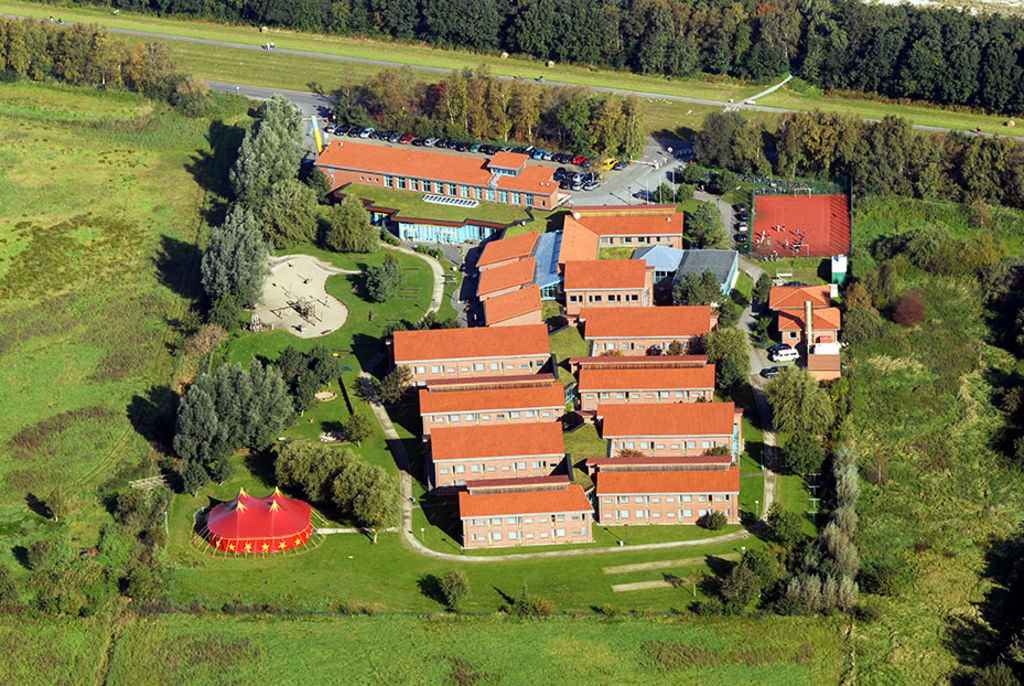 Luftaufnahme der Gebäude der Ostseeklinik eingebettet in grüne Küstenlandschaft.